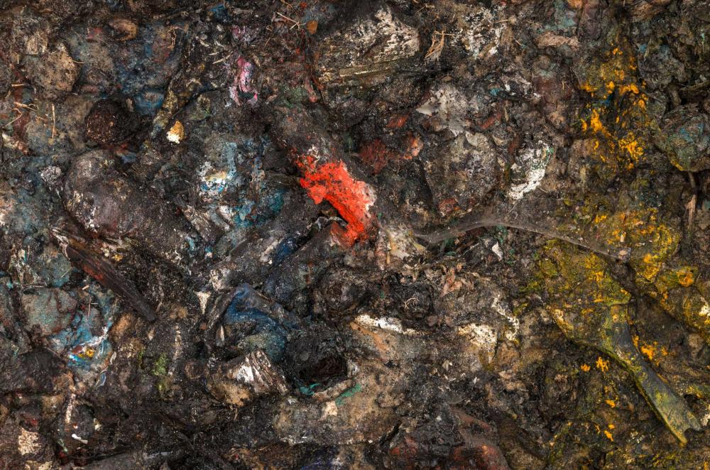 Überwiegend bräunliche Masse aus kaum unterscheidbaren Gegenständen, an einigen Stellen von roten, gelben oder blauen Farbtupfern unterbrochen.