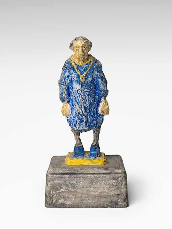 A female plaster figure with a blue dress and a golden necklace with a Star of David looks sadly to the ground and hangs her shoulders.
