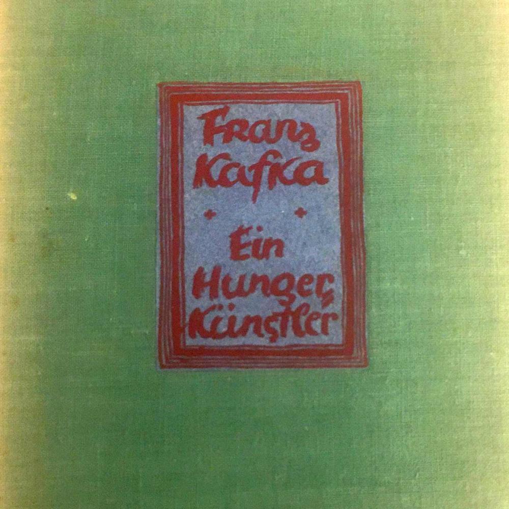 Detail of a green book cover with a glued-on, red-framed label with the inscription: “Franz Kafka, Ein Hungerkünstler” (A Hunger Artist).