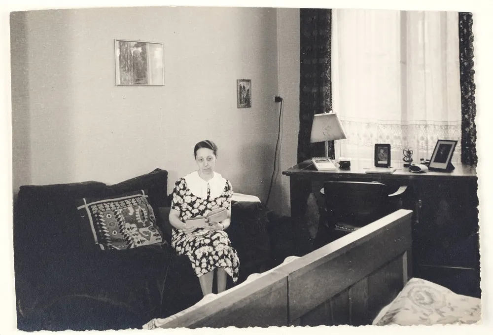 Black-and-white photography: a woman sitting on a sofa holding a book in her hands
