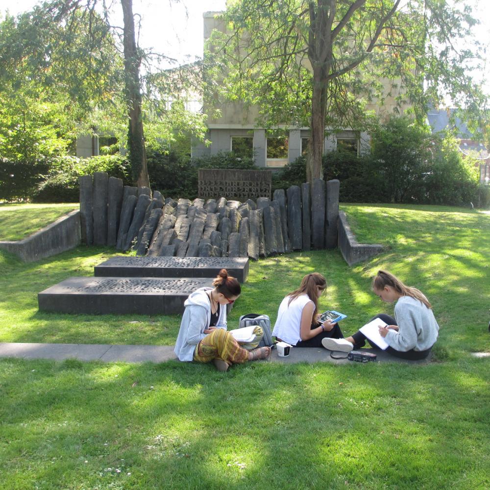 Young people on a park lawn with writing implements