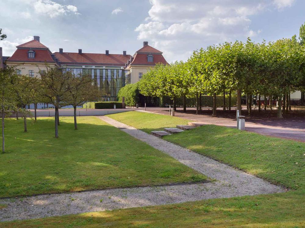 Green garden, baroque building in the background.