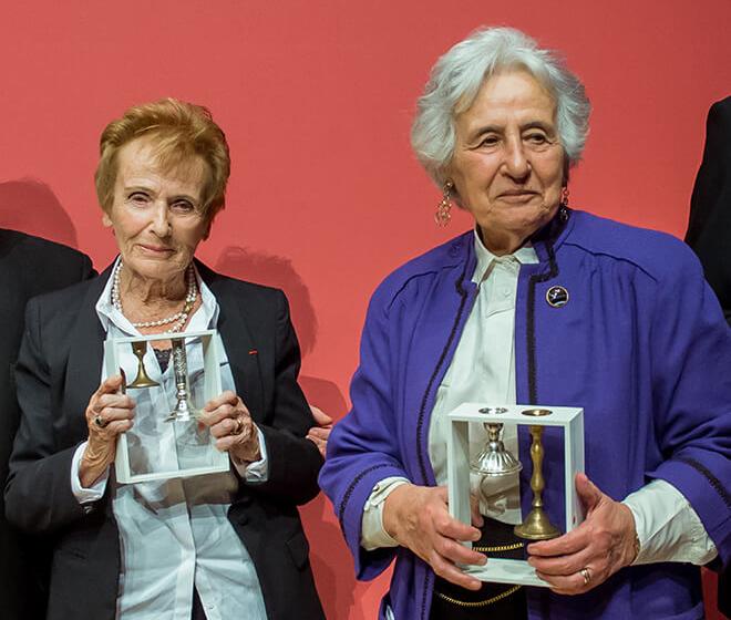 Two smiling ladies are presenting the award