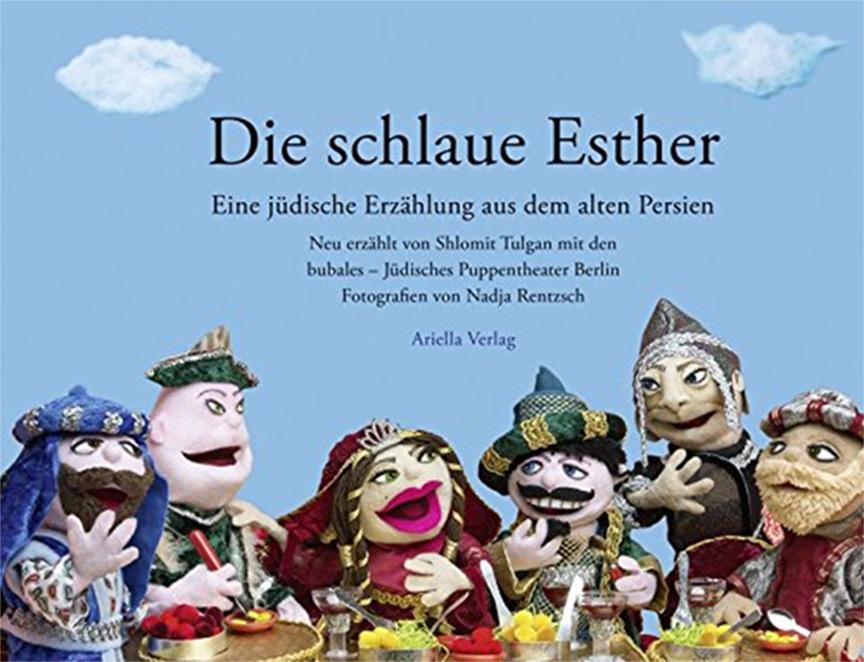 Buchcover mit einem Bild vieler Stoffpuppen vor blauem Hintergrund