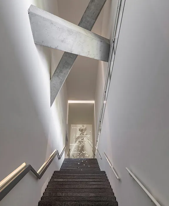 Long staircase with projected Hebrew and Latin letters that form city names