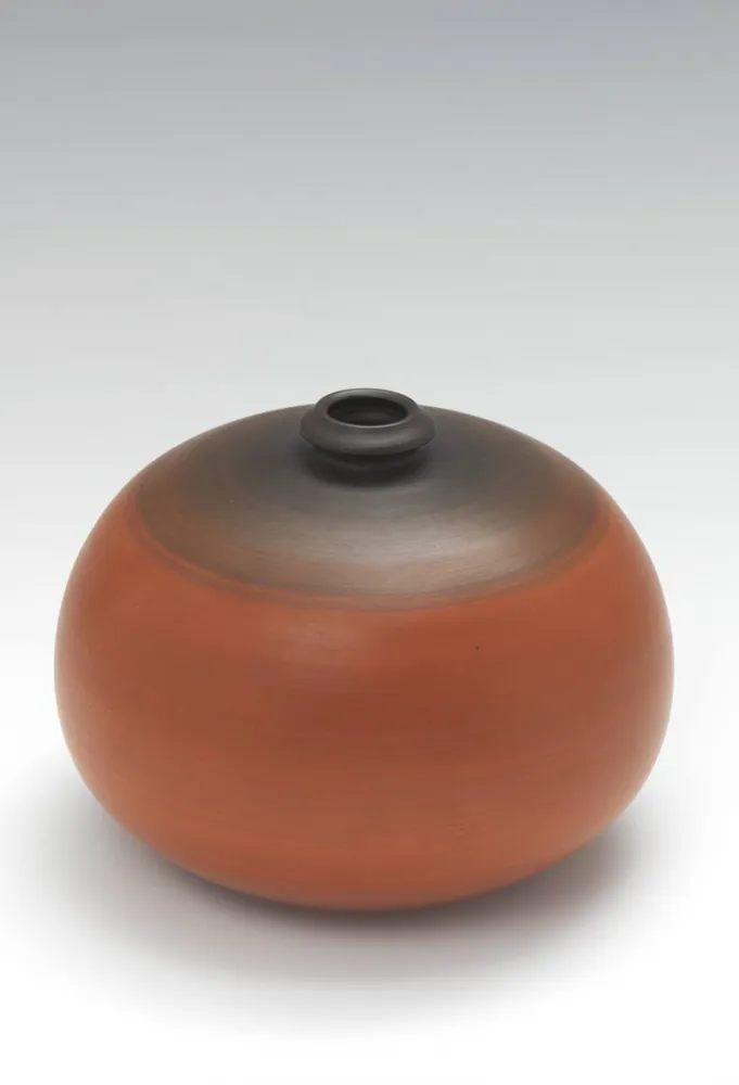 Orang and brown spherical vase with a small opening
