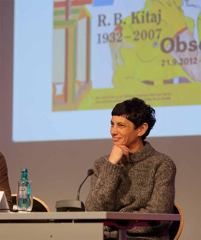 Junge Frau mit schwarzem Kurzhaarschnitt auf einem Podium