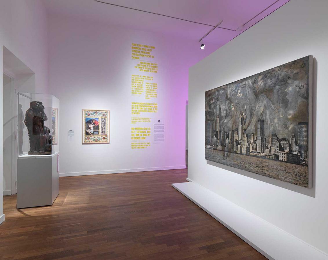 Exhibition view, on the left in the room is a sculpture in a display case, on the right hangs a painting on the wall.