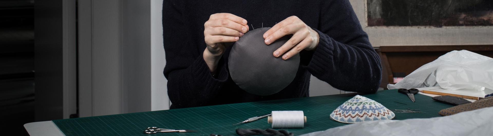 Woman embroiding a kippa.