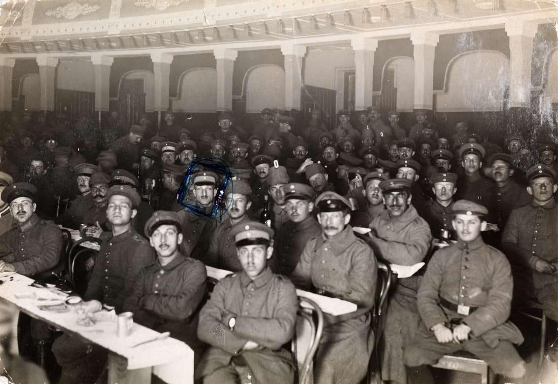 Men in uniform occupy seats in a theater auditorium.