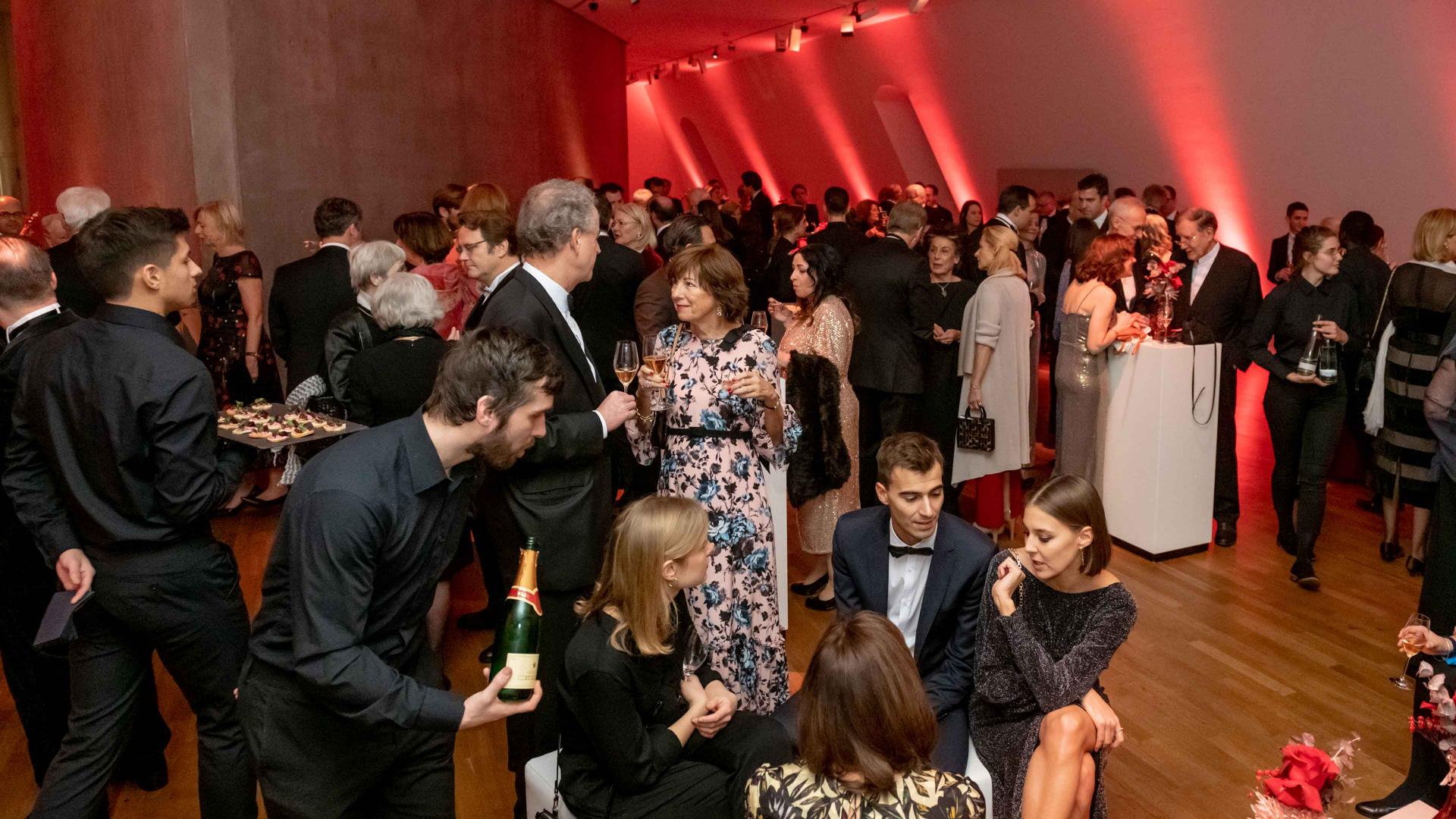 People in evening dress, champagne and appetizers are distributed.