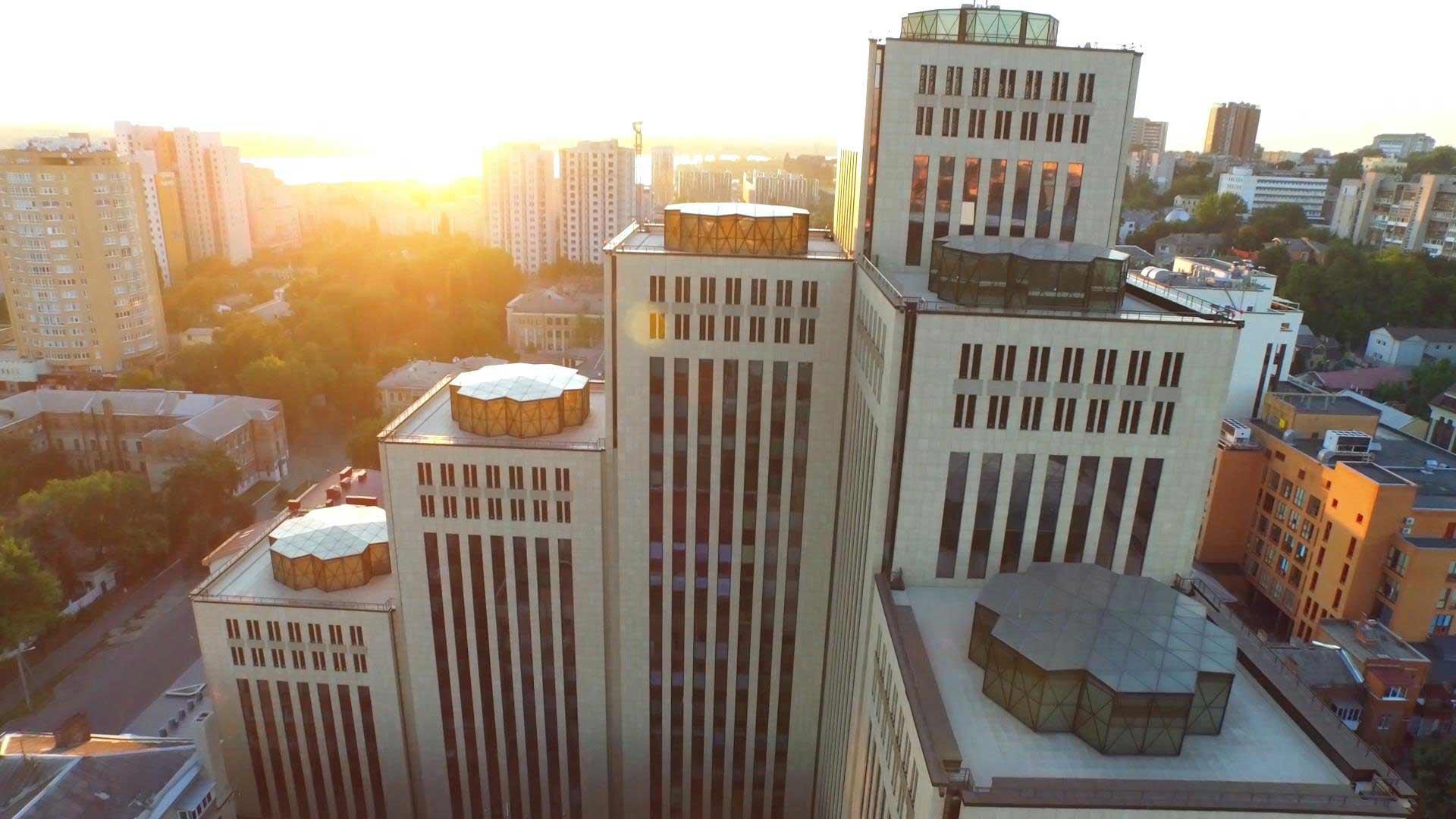 Bird's eye view of a city, in the foreground a modern building with many high towers.