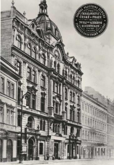 Black and white photo of an old five-story building with a cupola in a street front.