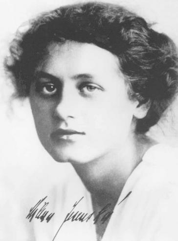 Black and white portrait of a young woman with a pinned-up hairstyle and signature on the picture: “Milena Jesenska.”