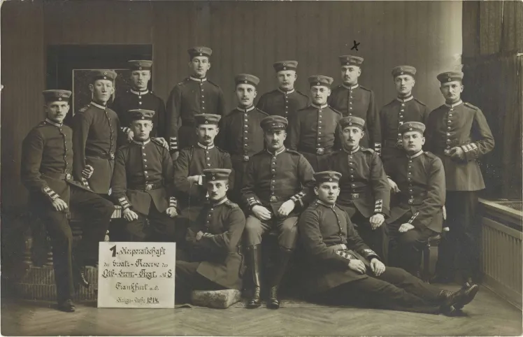 Schwarz-weiß-Foto: 17 uniformierte Soldaten, stehend oder sitzend, Atelieraufnahme