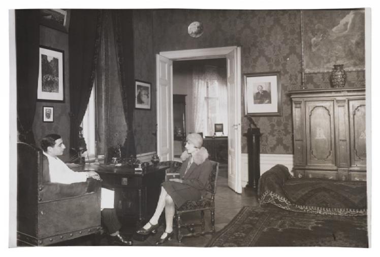 Black and white photography of a woman and a man sitting in arm chairs across each other