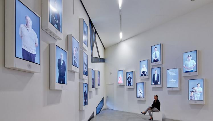 Room view with monitors on the wall showing many different people